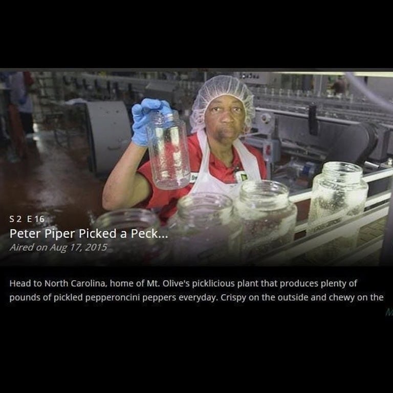 Worker inspecting jars of pickled peppers at Mt. Olive Pickles factory.