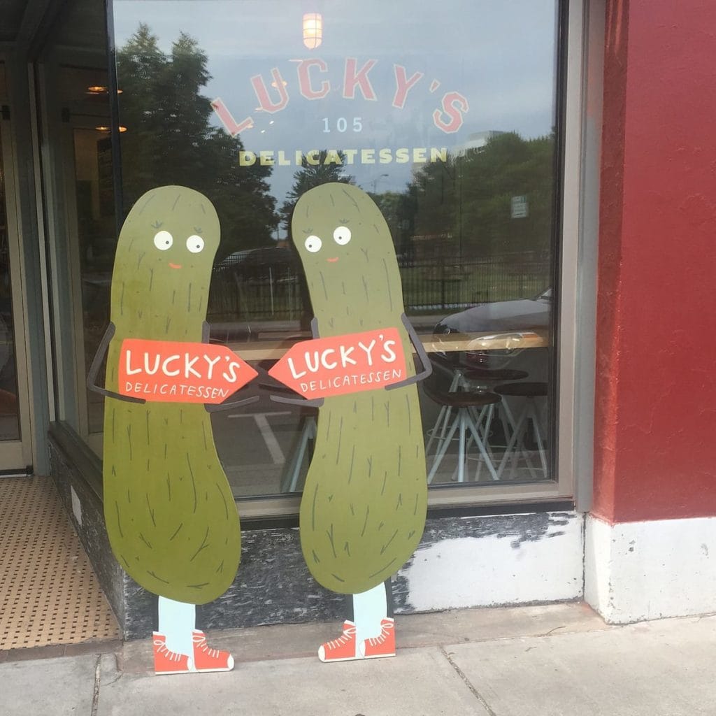 Two large wood sign cutouts of Pickles with eyes and legs/feet