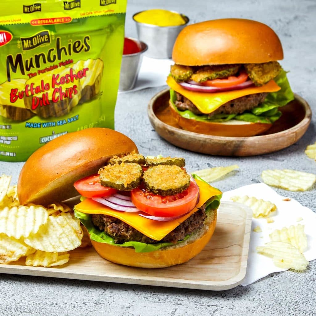 burgers with cheese tomatoes and fried pickles, side of chips, bag of munchies pickles