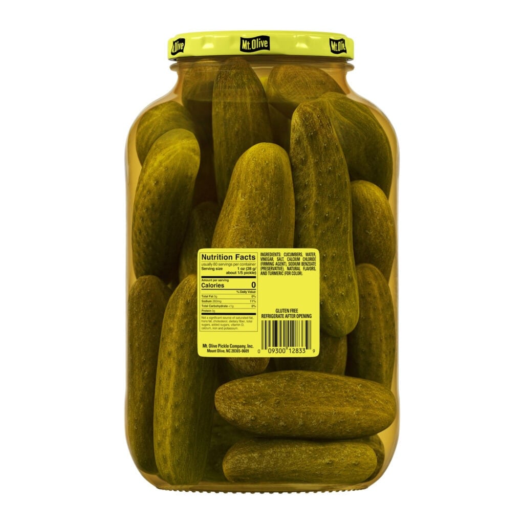 Jar of Mt Olive Kosher Dill Pickles with fresh cucumbers inside.