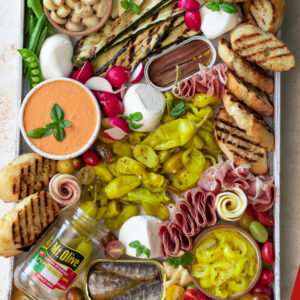 antipasti platter with meats, salami, cheeses, peppers, crostini bread sticks, veggies and red pepper dip