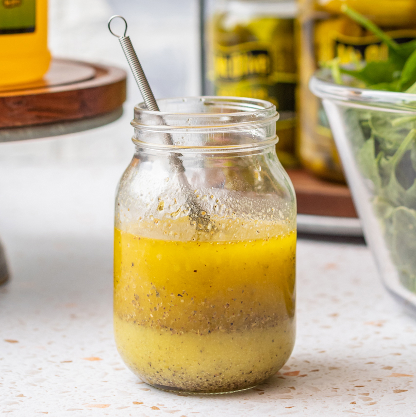 jar of salad dressing with whisk in it