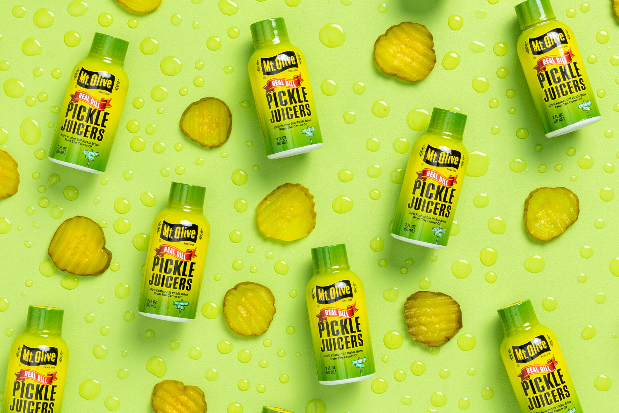 pickle juicers 2 oz bottles with pickle chips and droplets of pickle juice
