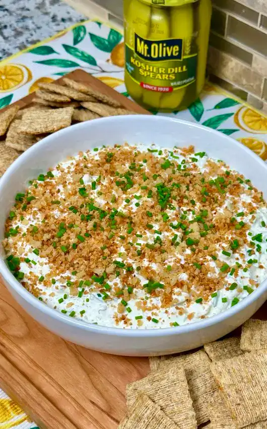 Creamy fried pickle dip garnished with chives and breadcrumbs.