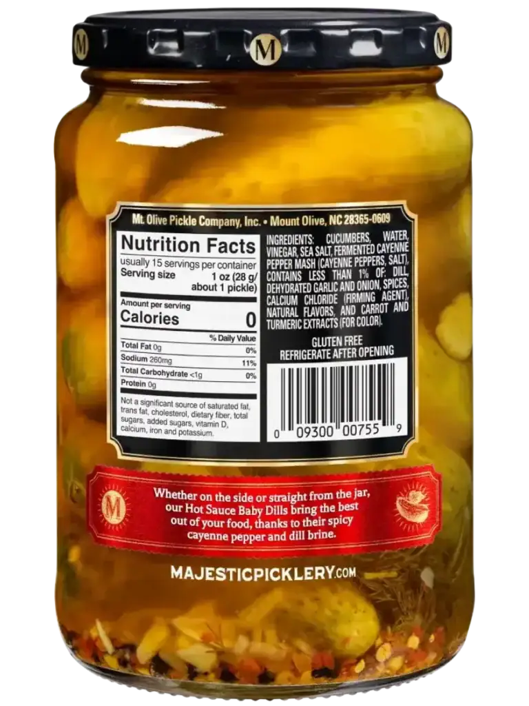 Jar of Mt Olive Baby Dills with spices and peppers inside.