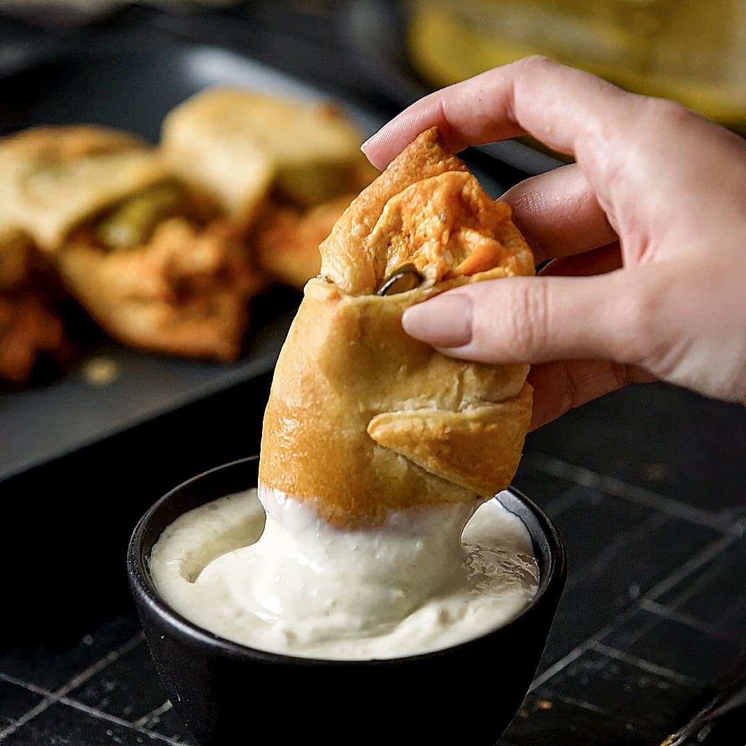 Bufffalo Chicken Pickle Crescent Roll being dipped into ranch dressing