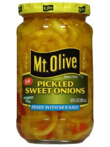 A jar of Mt. Olive Pickled sweet onions sits against a white backdrop.