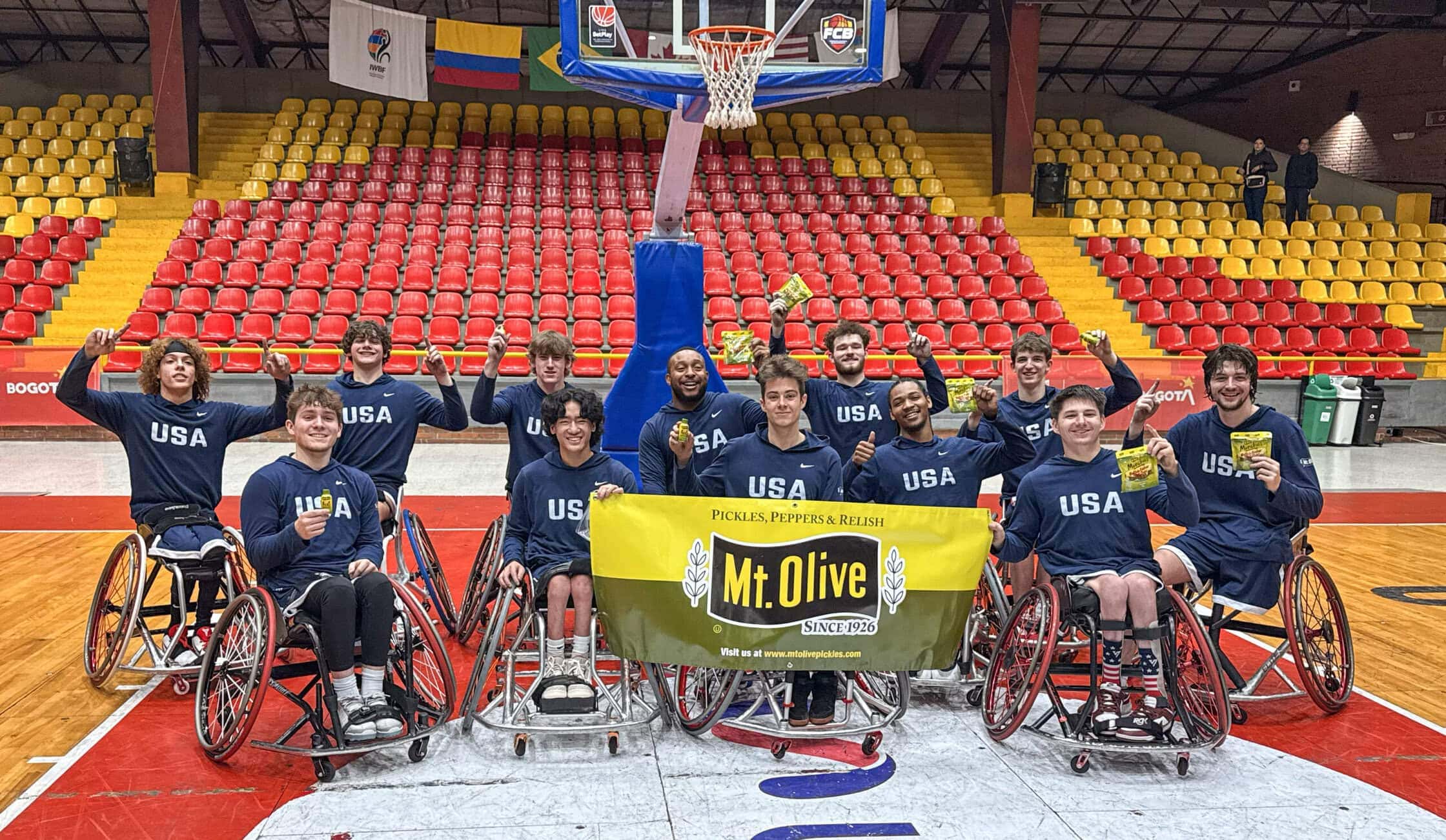 NWBA team holding a Mt. Olive banner in front of the seats and basketball hoop.