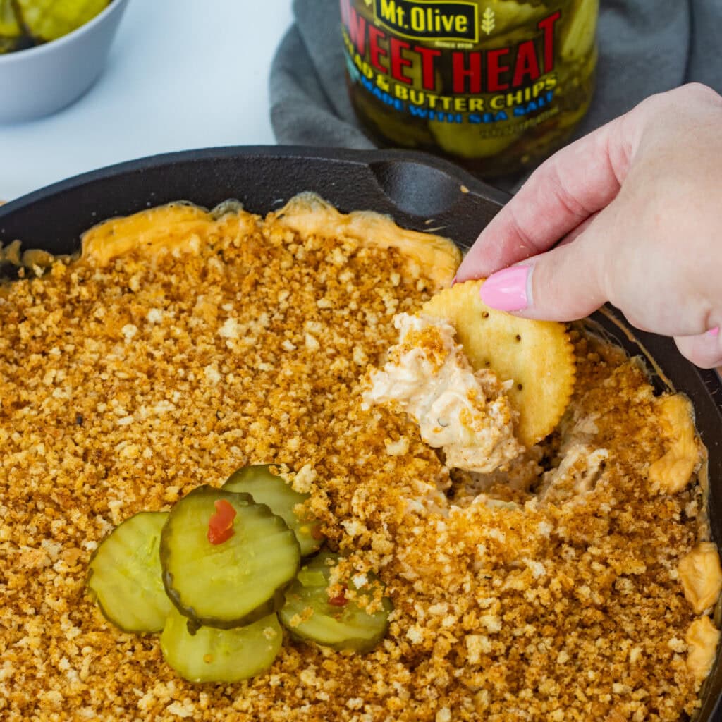 Sweet heat pickles arranged on top of a dish of Nashville Hot Chicken Dip.