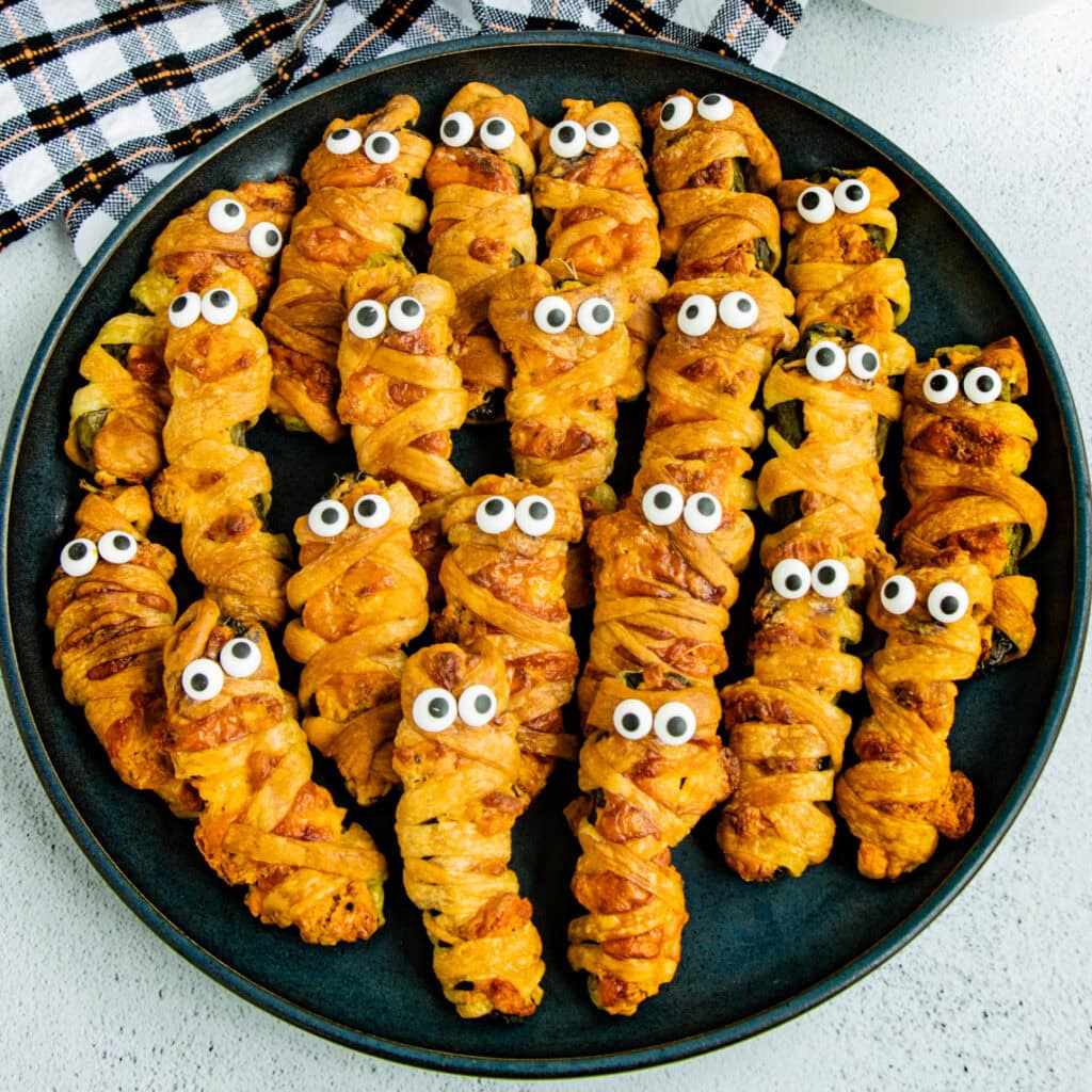 Mummy Pickle Poppers on a black plate.