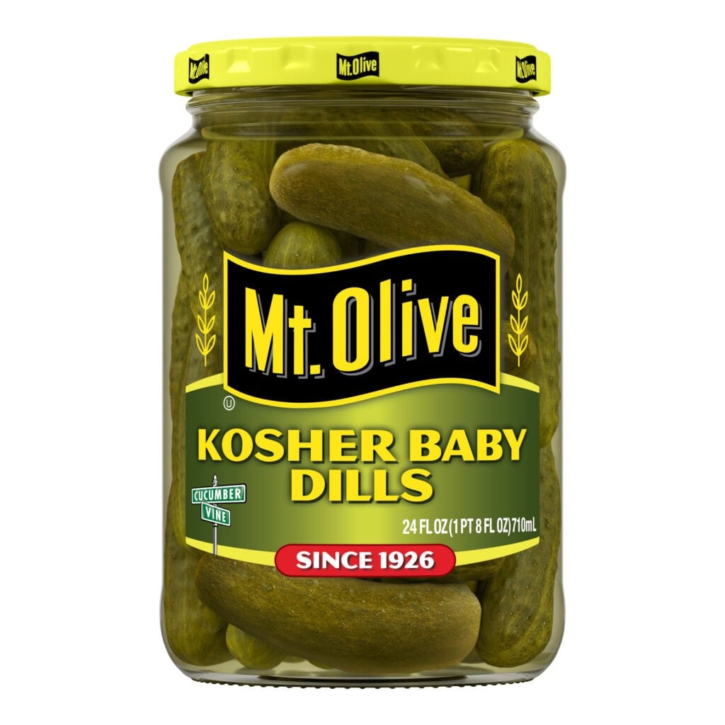 Jar of Mt Olive Kosher Baby Dills pickles with bright yellow lid.
