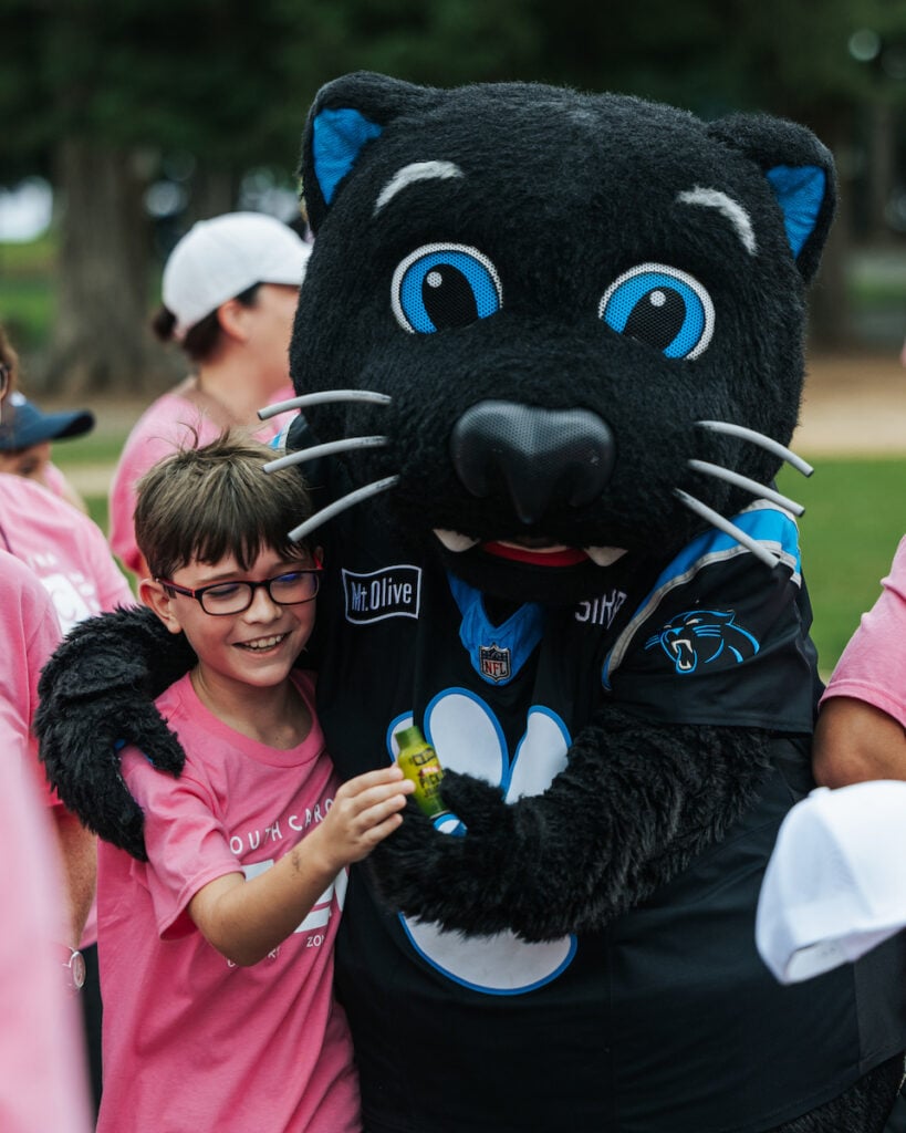 Sir Purr mascot with children at Comfort Zone Camp event.